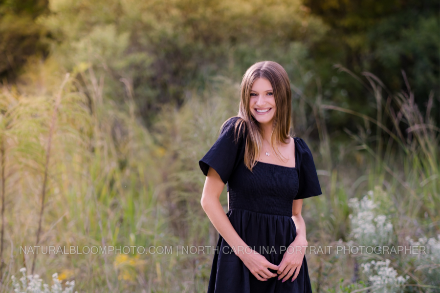golden hour senior girl picture in black dress in a field